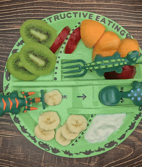 Dino Dish kids plate with dinosaur utensils moving playfully during mealtime.